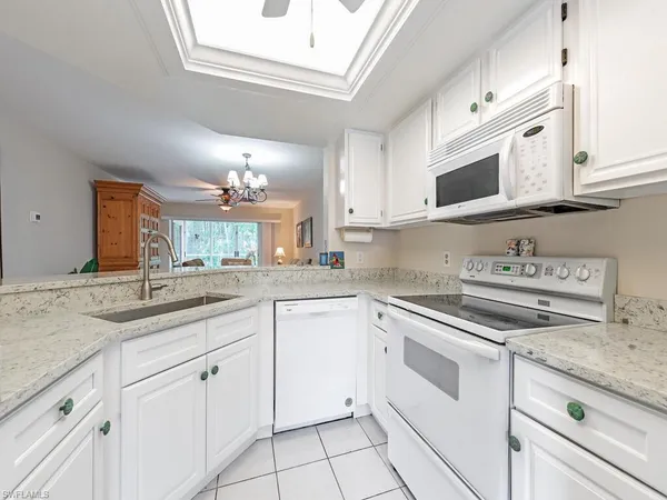 a kitchen with white cabinets and appliances