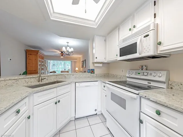 a kitchen with white cabinets and appliances