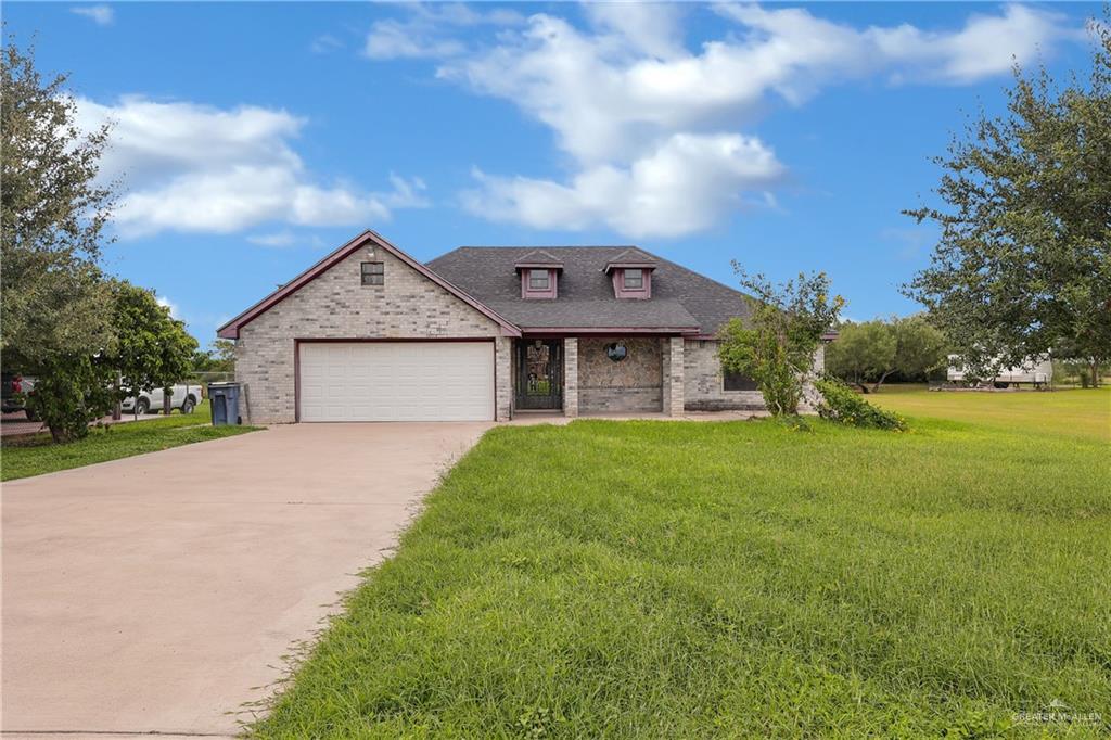 French country home with a garage and a front yard