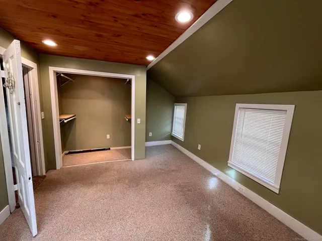 an empty room with closet and windows