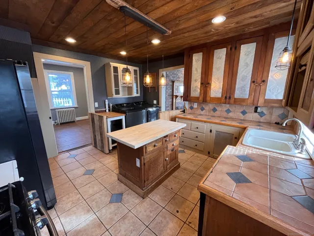 a kitchen with a sink a counter top space appliances and cabinets