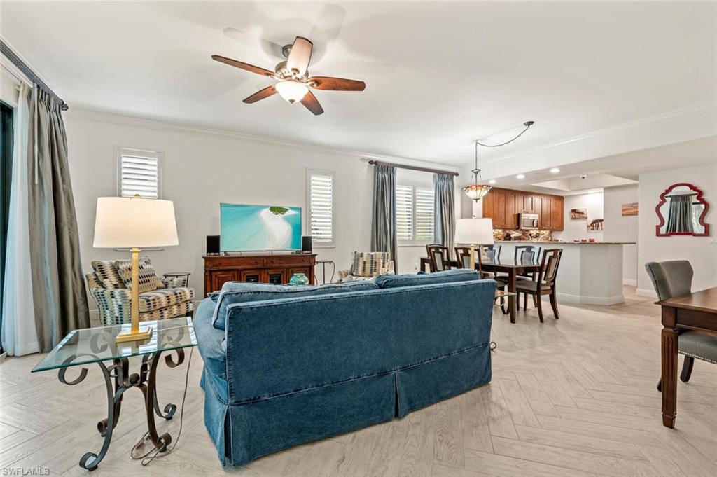 1035 Sandpiper Street, Unit F104 Naples, FL 34102 - Photo 3 of 24 a living room with furniture and a table