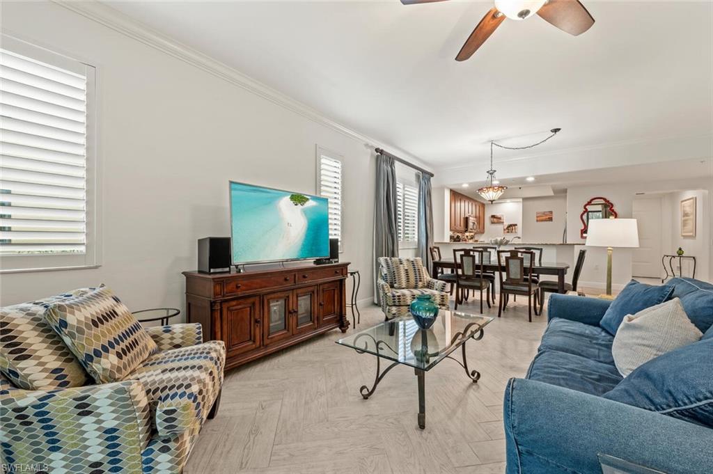 1035 Sandpiper Street, Unit F104 Naples, FL 34102 - Photo 4 of 24 a living room with furniture and a flat screen tv