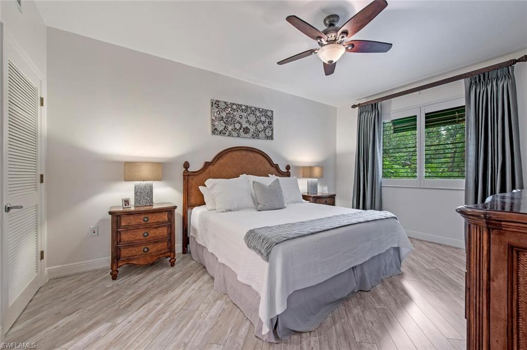 1035 Sandpiper Street, Unit F104 Naples, FL 34102 - Photo 7 of 24 a bedroom with a bed and a large window