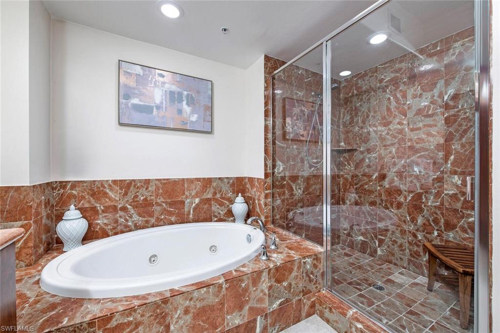 1035 Sandpiper Street, Unit F104 Naples, FL 34102 - Photo 10 of 24 a bathroom with a bathtub and shower