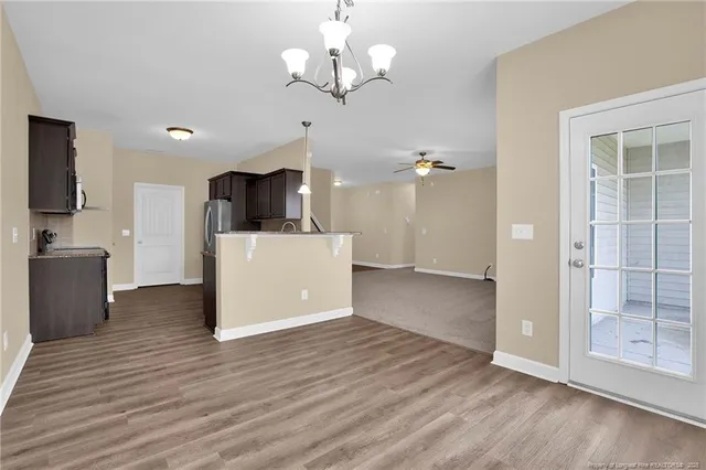a view of a kitchen with a refrigerator a microwave and a wooden floor