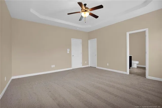 a bathroom with a granite countertop sink a toilet and a mirror
