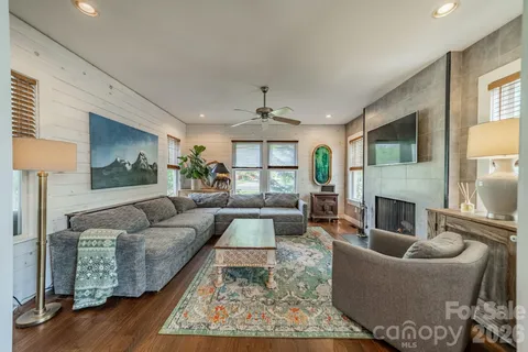 a living room with furniture a fireplace and a flat screen tv