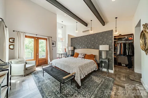 a bedroom with a bed a large window and walk in closet