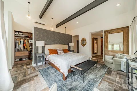 a bedroom with a bed a mirror and lamp