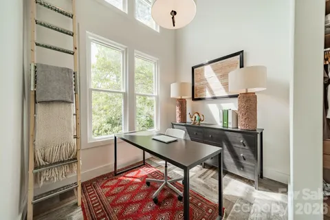a view of a workspace with furniture and a window