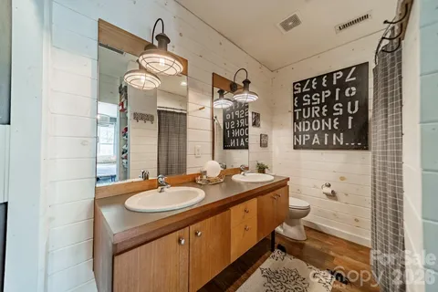 a bathroom with a double vanity sink toilet and shower