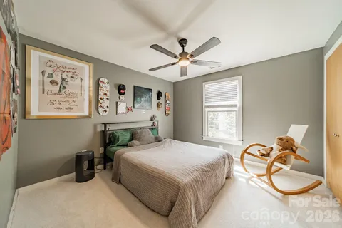 a bedroom with a bed a chandelier and a window