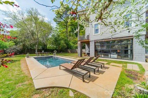a view of swimming pool with sitting area and garden
