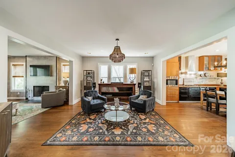 a living room with furniture a rug and kitchen view