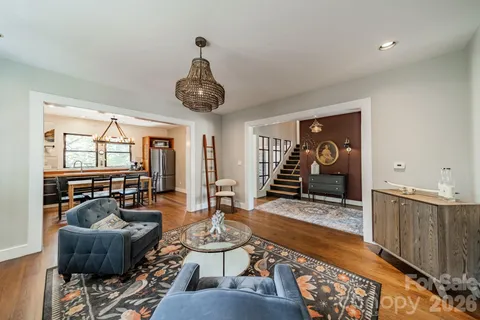 a living room with furniture and a chandelier