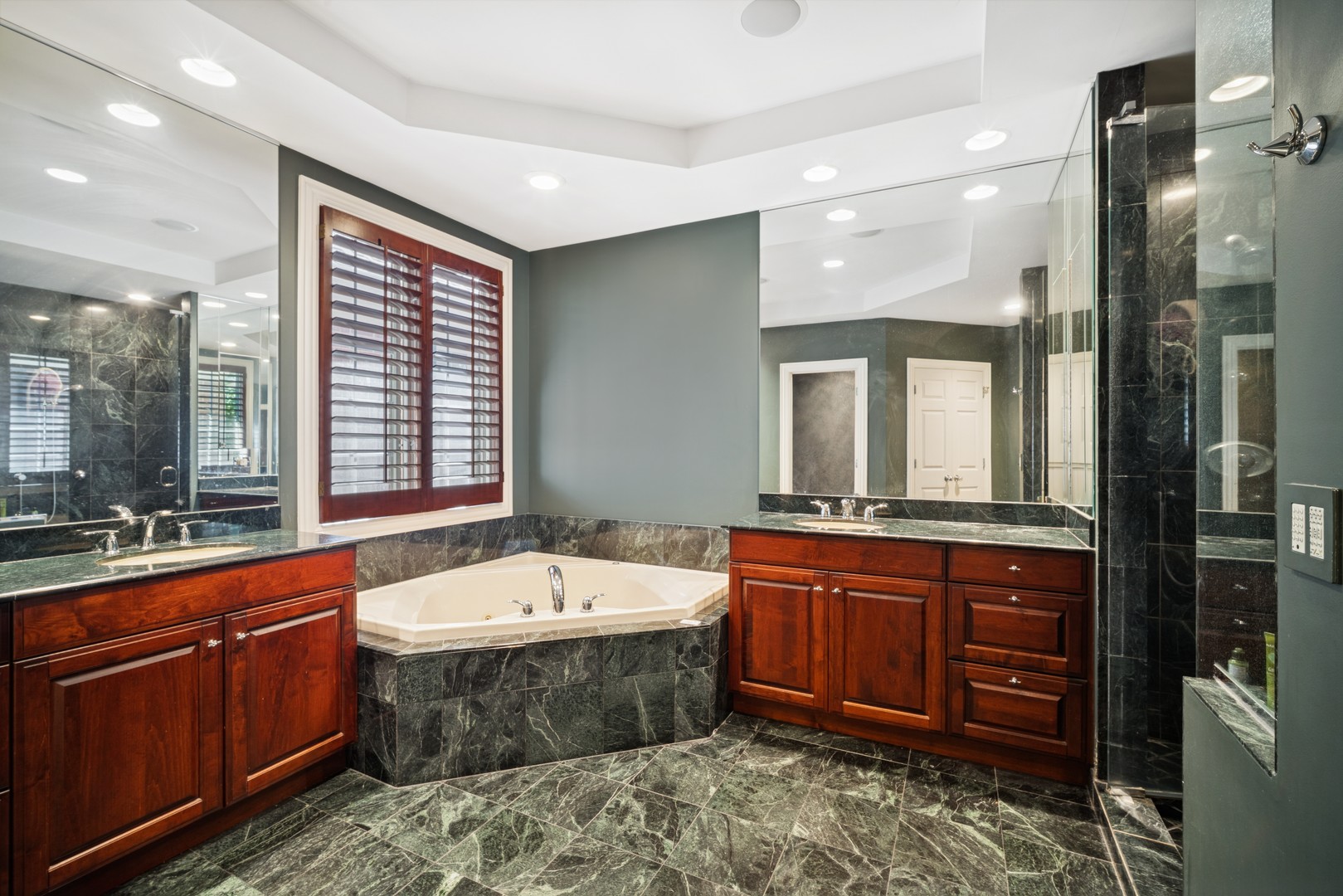 857 Country Club Lane Northbrook, IL 60062 - Photo 10 of 27 a bathroom with a tub a sink double vanity and a large mirror