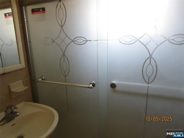 a bathroom with a sink a window and a shower