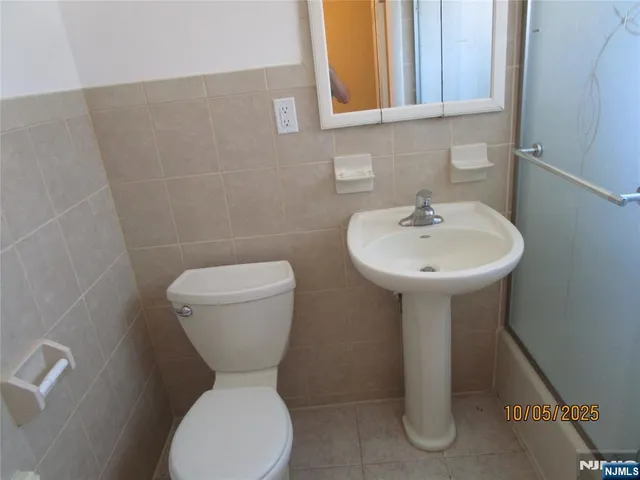 a bathroom with a toilet sink and mirror