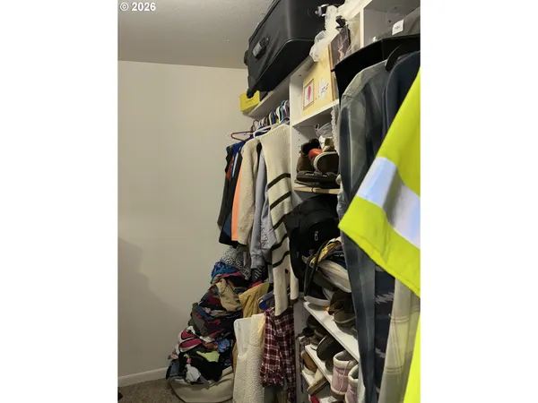 a view of walk in closet with clothes and shoes