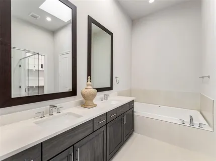 a bathroom with a tub a sink and mirror