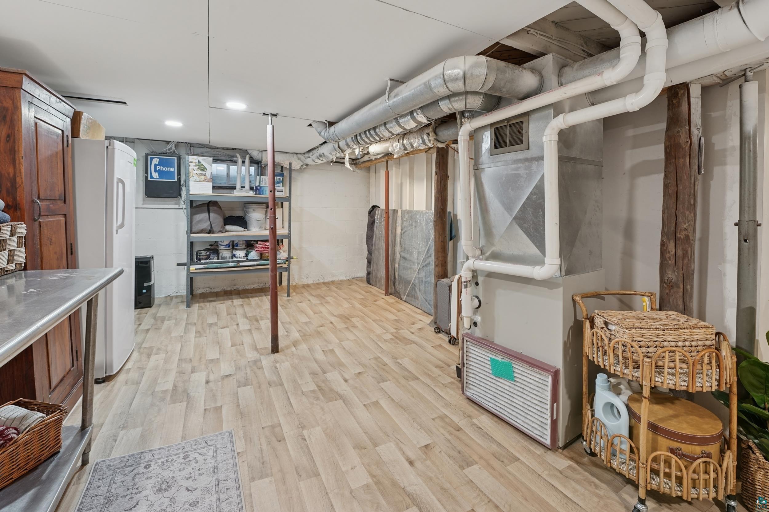 52 Thomson Road Esko, MN 55733 - Photo 14 of 20 Unfinished below grade area with light wood-style floors, freestanding refrigerator, and heating unit