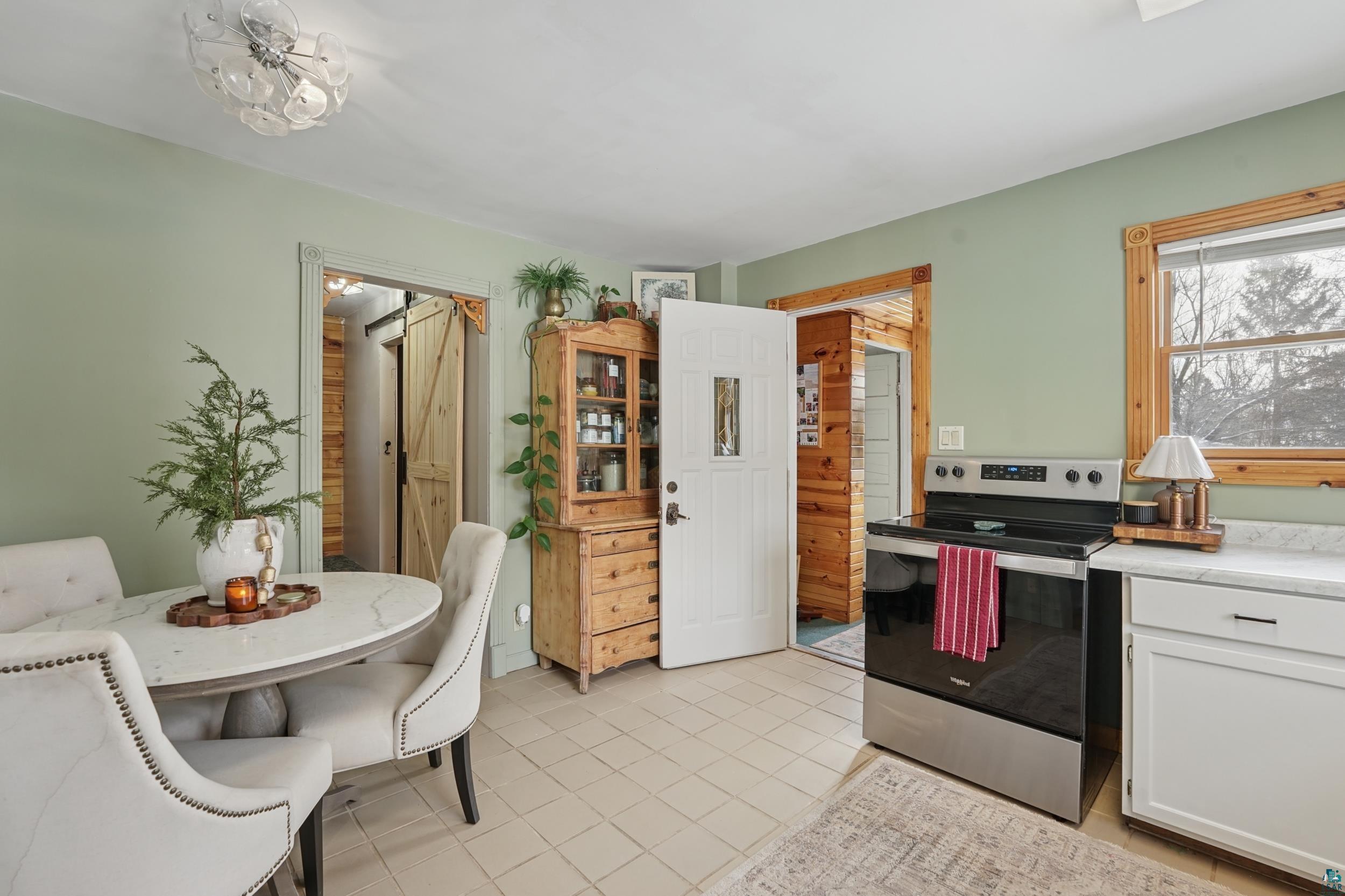 52 Thomson Road Esko, MN 55733 - Photo 4 of 20 Kitchen featuring stainless steel range with electric cooktop, white cabinets, light tile patterned floors, and light countertops