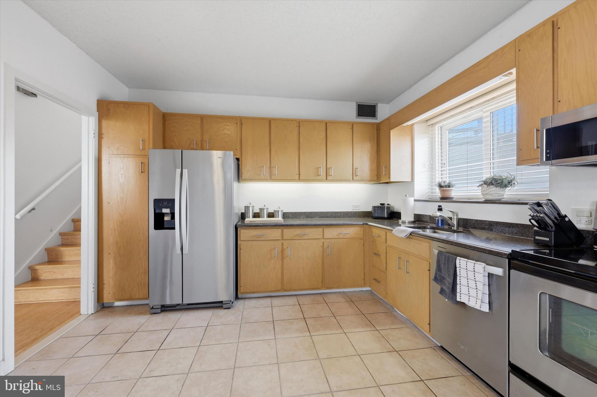 2301 Cherry Street, Unit 4A Philadelphia, PA 19103 - Photo 3 of 25 a kitchen with a sink a refrigerator and cabinets