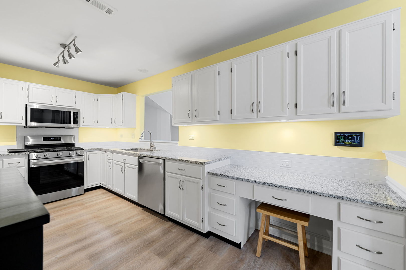 1264 Rhodes Lane Naperville, IL 60540 - Photo 23 of 35 a kitchen with granite countertop a stove a sink and dishwasher with white cabinets