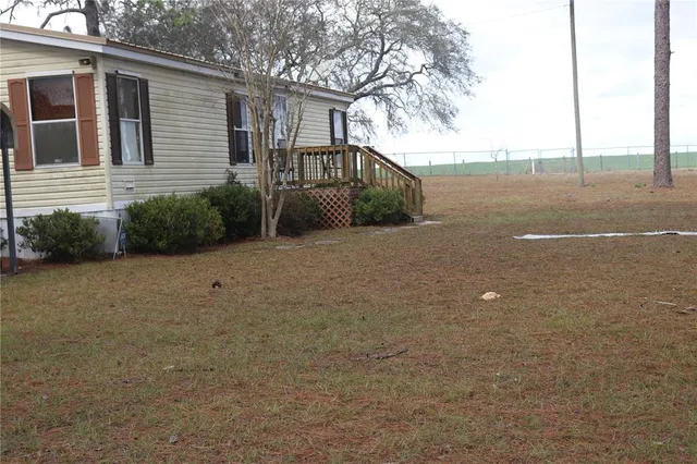 a view of a house with backyard and trees