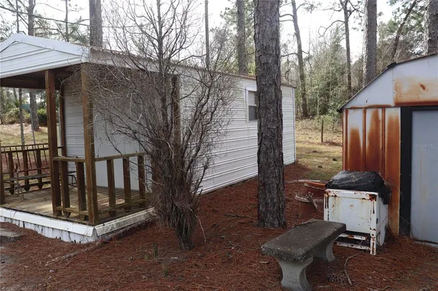 a view of backyard with barbeque grill and wooden fence