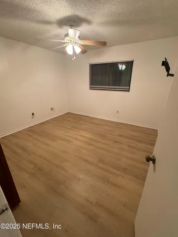 a view of an empty room with a chandelier fan