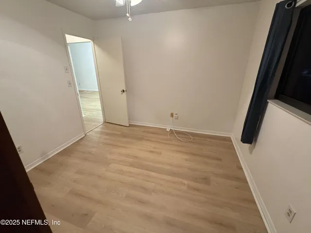 an empty room with wooden floor and white door
