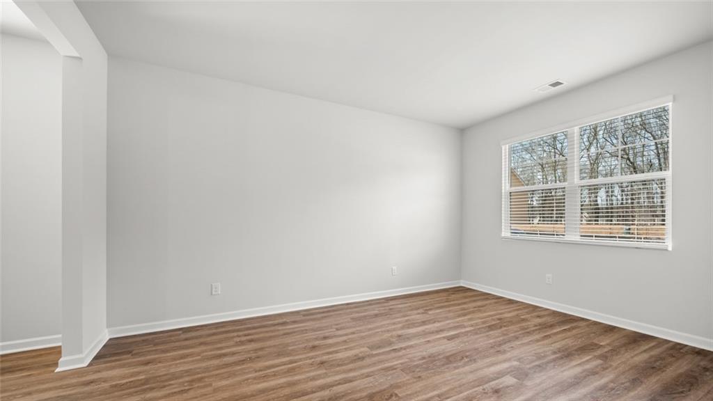 113 Oakchase Pk Lane Hampton, GA 30228 - Photo 6 of 34 a view of an empty room with wooden floor and a window