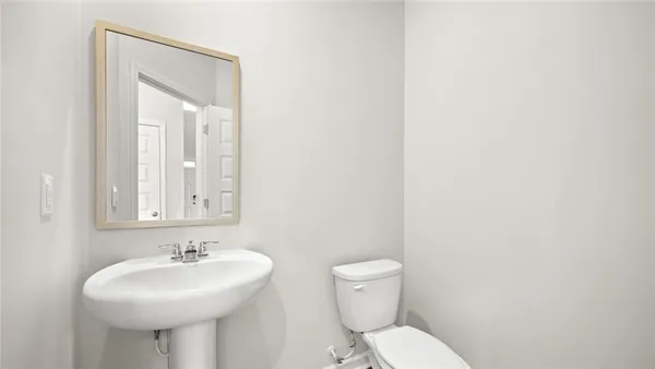 a bathroom with a sink a toilet and mirror