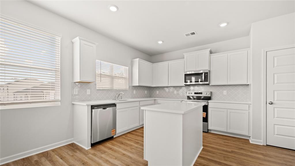 113 Oakchase Pk Lane Hampton, GA 30228 - Photo 10 of 34 a kitchen with stainless steel appliances granite countertop a sink a stove a refrigerator and cabinets