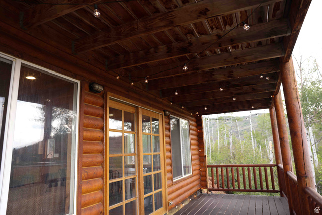 15253 Mill Road, Unit 62 Huntsville, UT 84317 - Photo 39 of 48 Expansive wooden deck featuring log column supports, a wooden railing, and string lighting