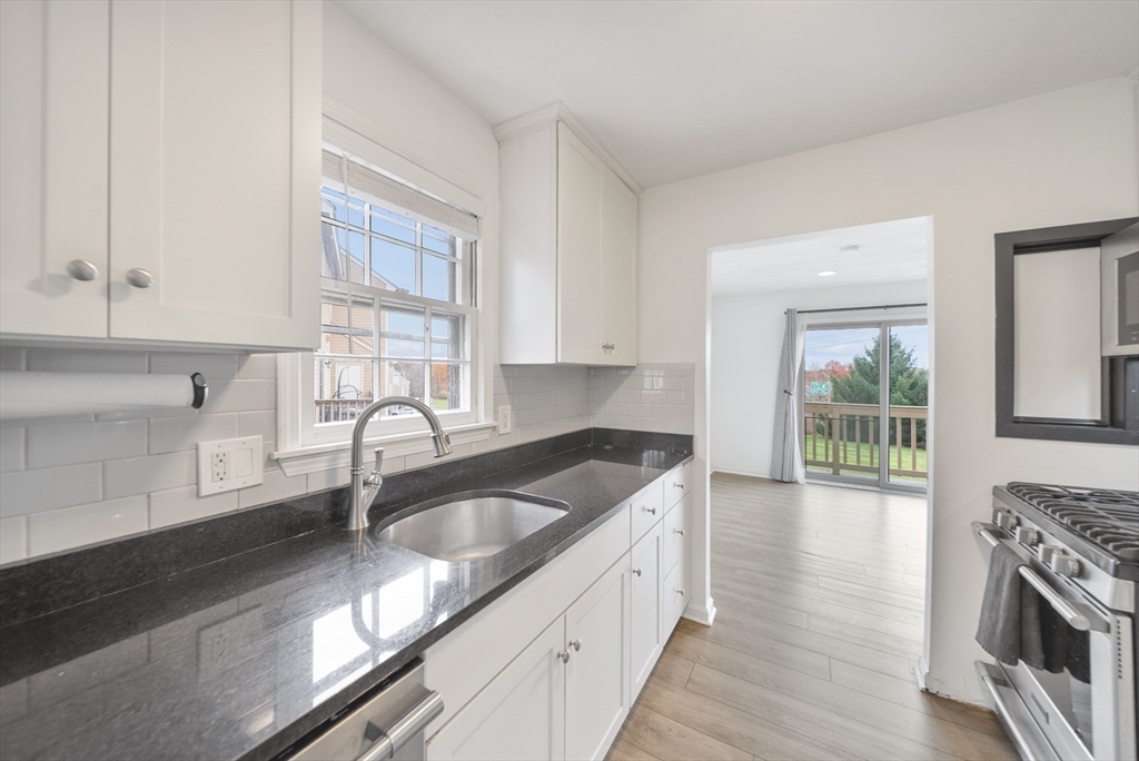 45 Washington Street, Unit 55 Methuen, MA 01844 - Photo 13 of 36 a kitchen with granite countertop a sink a stove and cabinets