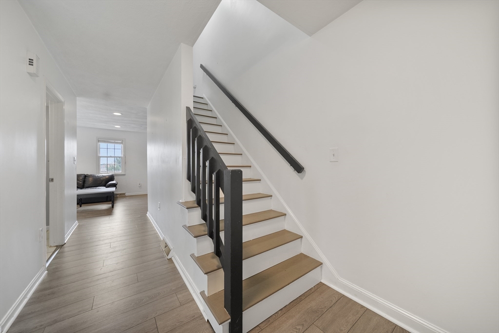 45 Washington Street, Unit 55 Methuen, MA 01844 - Photo 5 of 36 a view of a hallway with wooden floor and staircase