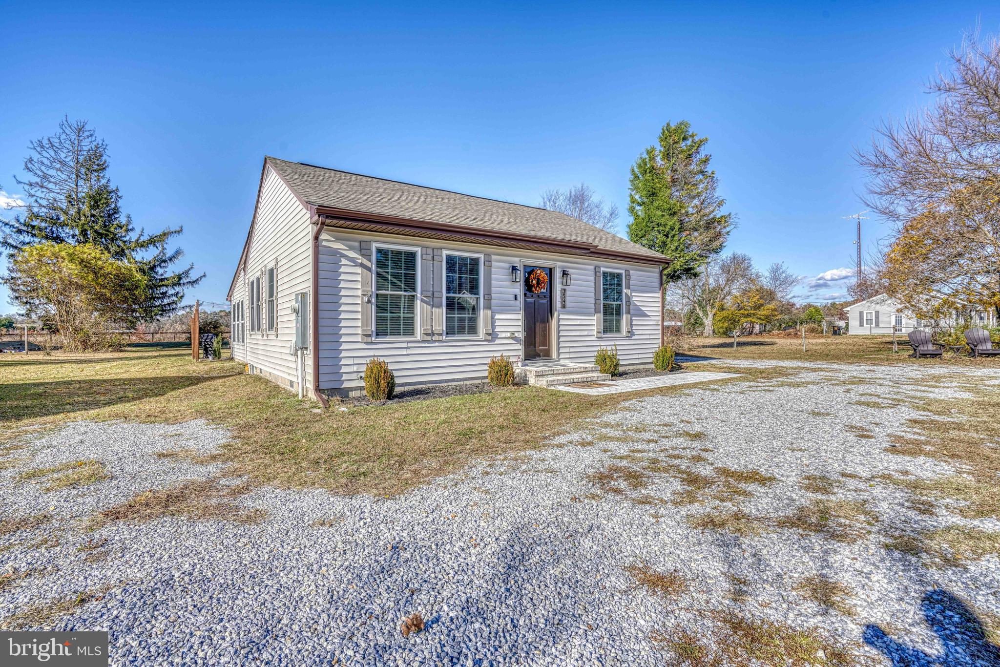 a view of a house with backyard and trees