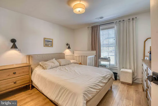 a bedroom with a bed and a flat tv screen on dresser