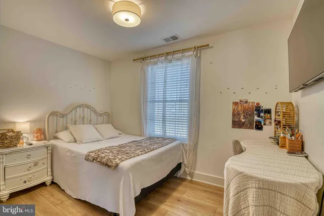 a bedroom with a bed and a lamp on dresser