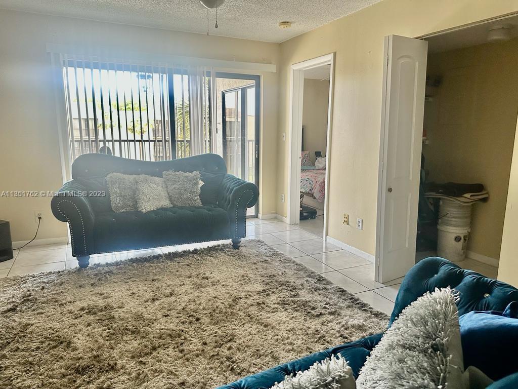 3199 Foxcroft Road, Unit 309 Miramar, FL 33025 - Photo 8 of 21 a living room with furniture and a rug