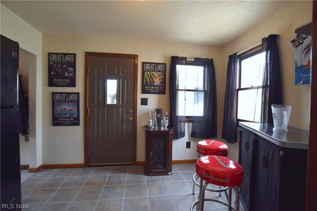 136 Sunset Road Avon Lake, OH 44012 - Photo 13 of 25 Standing in kitchen which opens into back room currently used as bar could also be dining area. Door leads to backyard. Laundry room on left.