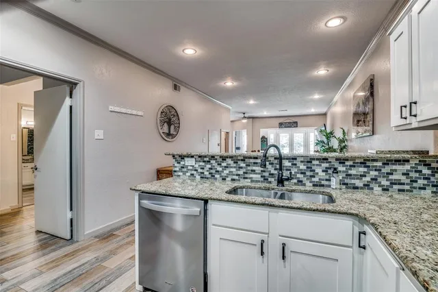 a kitchen with stainless steel appliances granite countertop a sink and a refrigerator