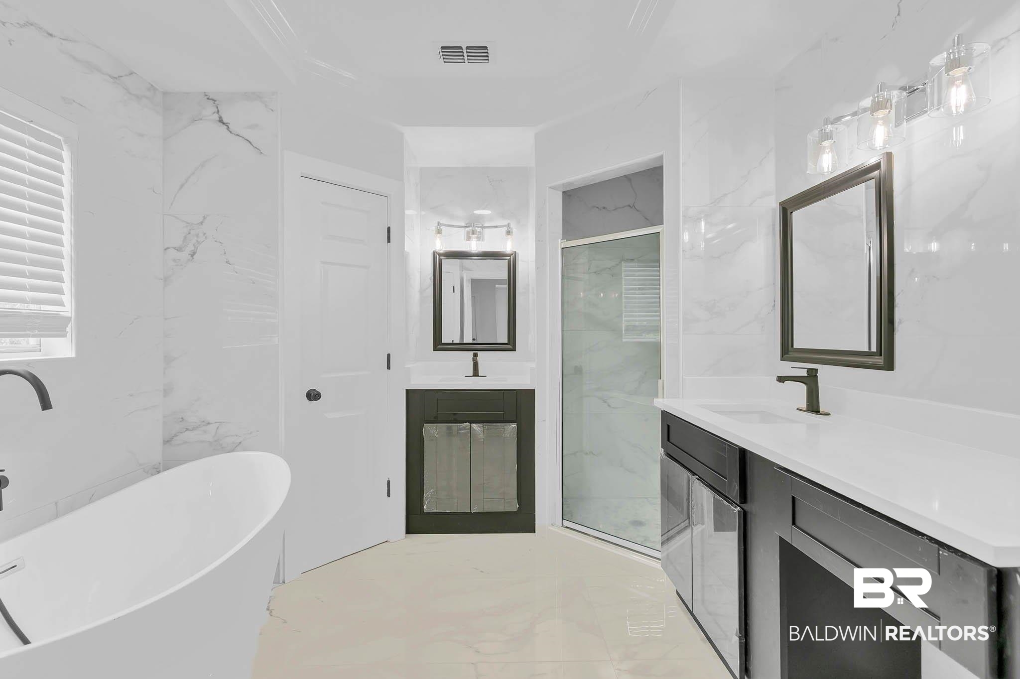 4705 Sherry Court Mobile, AL 36693 - Photo 39 of 100 Bathroom featuring light marble finish flooring, stone wall, a soaking tub, two vanities, and a marble finish shower