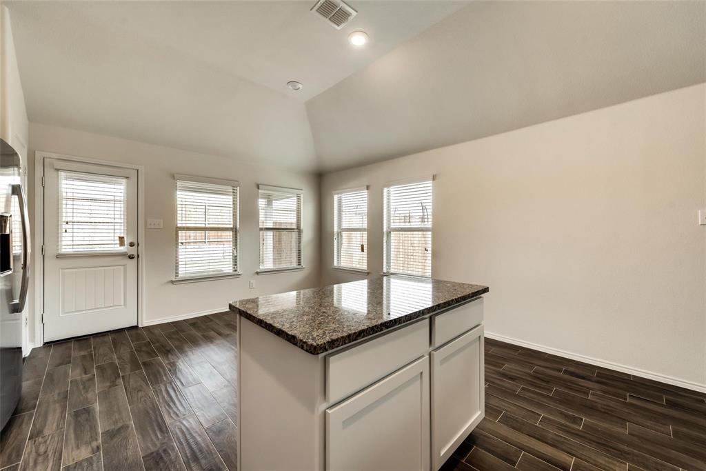 233 Pitt Circle Fate, TX 75189 - Photo 7 of 21 a kitchen with granite countertop a sink and dishwasher with wooden floor
