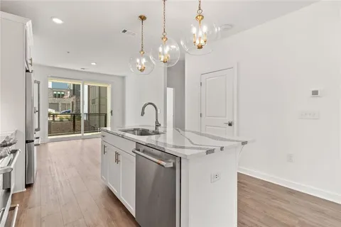 a view of a kitchen sink and wooden floor