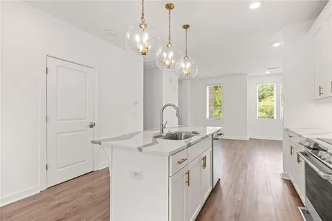a kitchen that has a lot of white cabinets and wooden floor