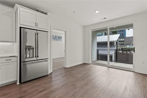 a kitchen with stainless steel appliances wooden floor and refrigerator